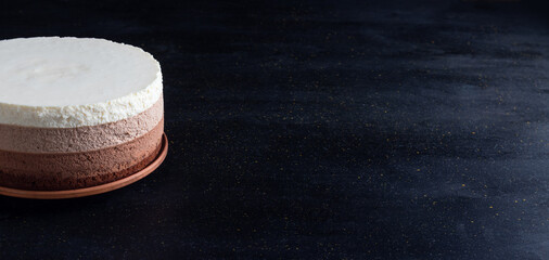 Triple chocolate mousse cake. Cream cake on black background. With copy space.