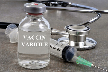 Concept de flacon de vaccin contre la variole avec une seringue et un stéthosocpe sur fond gris