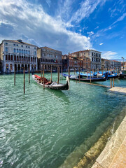 Line of gondolas at the great channel in Venice, Italy lying peacefully tied to the polls with no...