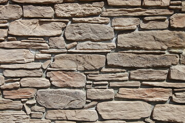 The wall is made of finishing stone. Stone tiles. Slate stone.