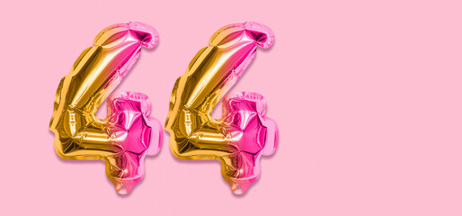 Rainbow foil balloon number, digit forty four on a pink background. Birthday greeting card with inscription 44. Top view. Numerical digit. Celebration event, template. Banner
