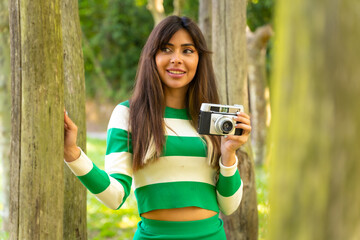 Brunette caucasian girl on vacation in nature taking photos with the camera