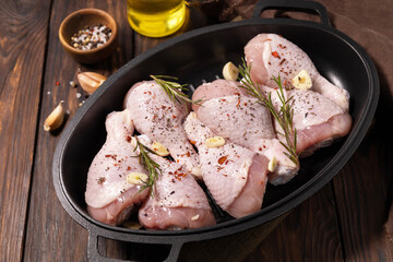 Raw chicken meat. Uncooked chicken legs on wooden cooking table background with spices.