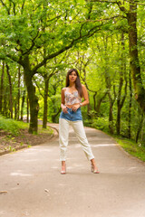 Obraz premium Portrait of a Caucasian girl on a path in a city park, fashionably posed in nature