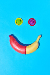 Vibrant shot of single banana with condom on hot blue background safe sex and protection concept