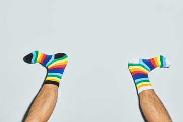 Minimal shot of playful man wearing mismatched socks feet up, copy space