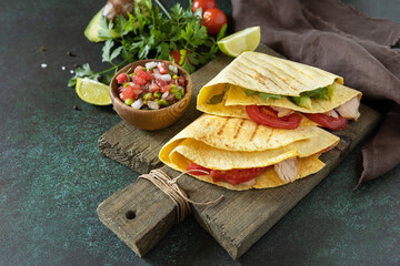 Healthy lunch. Tortilla sandwich, mexican wraps  with grilled chicken fillet and avocado, served with guacamole. Copy space.
