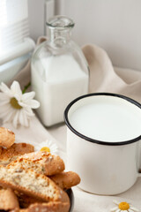 White rustic cup and glass bottle with milk and kentucci dessert. selective focus