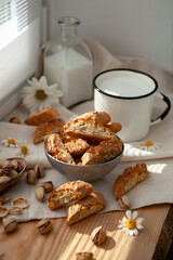 Italian kentucci with pistachio nuts in a metal plate stand on the table with a cup of milk and a carafe