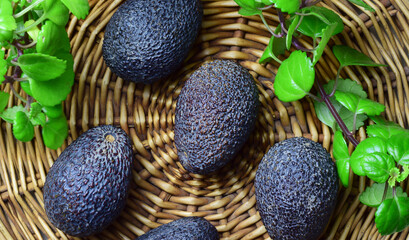 Fototapeta na wymiar Close up and zenith view, fruits, avocados on a wicker base, decorative natural plant.