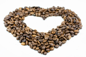 A heart made of roasted coffee beans on a gray (white) background. Place for the text (copy paste). Love of coffee. Good morning!