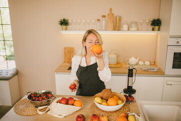 Millennial woman preparing ingridients for making smoothies at the kitchen