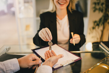 Happy couple buying a property, recieving a key from new apartment from real estate agent..