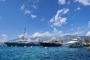 Naklejka premium Moored luxury yachts against the backdrop of a mountains and blue sky