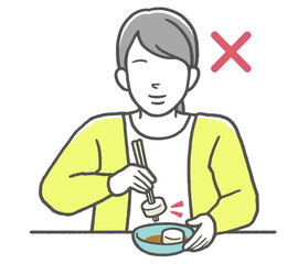 お箸のマナー違反　刺し箸をする女性