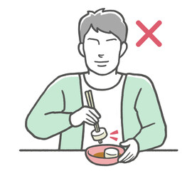 お箸のマナー違反　刺し箸をする男性