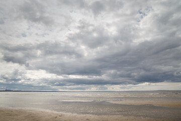 Landscape with sandy beach of the Gulf of Finland with low clouds.