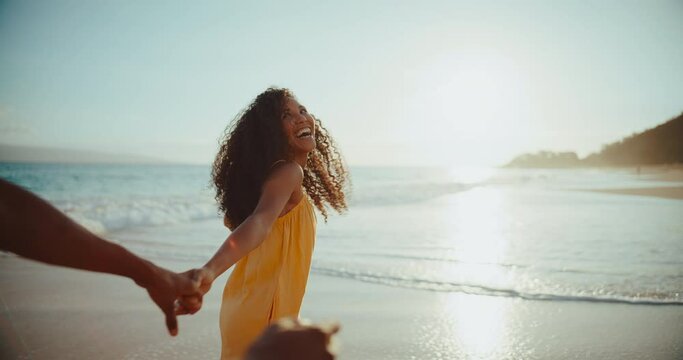 Beautiful young woman laughing and smiling with her boyfriend on the beach at sunset