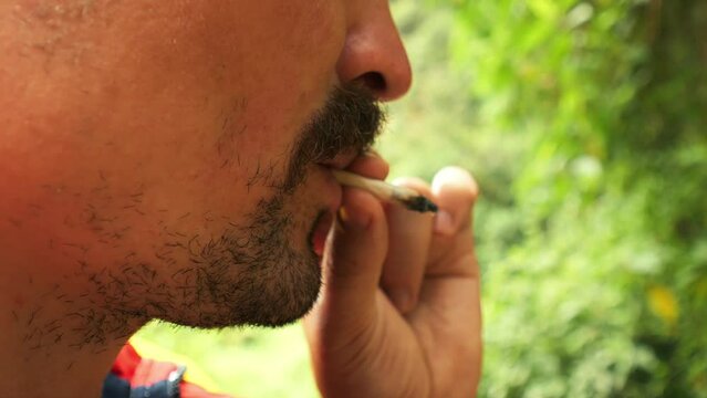 Undefined man smoking weed joint 4K slow-motion footage.