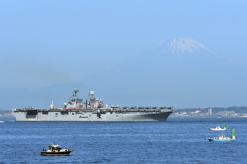 United States Navy amphibious assault ship USS Tripoli sailing in Tokyo Bay with Mt. Fuji in the...