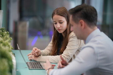 Young man consulting his business partner at meeting in office