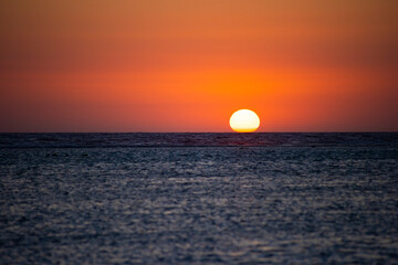 The sea swallows the sun disk
