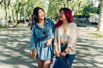 Two Asian women walking happily through the city.