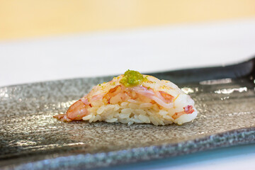 Ama ebi, or sweet shrimp Nigiri on Japanese Dish with copy space.