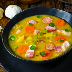 Hearty rustic pea soup with bacon and sausage
