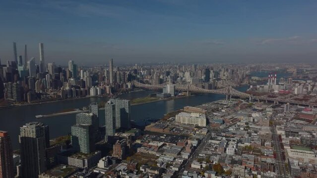 Aerial panoramic view of development in large city. Manhattan, Queens and Queensboro Bridge over river between. New York City, USA