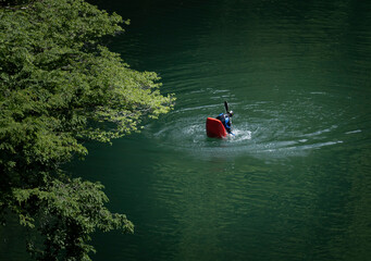Okutama, Tokyo Japan - 05 28 2022: Deep green water lake kayaking with safety . water sports, red and green colours 