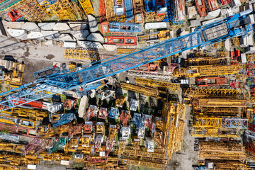 Fototapeta premium Storage place of high-rise cranes. Aerial view of yellow elements, industrial technology.