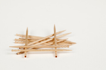 Closeup view of a pile of wooden toothpicks on a white bsckground
