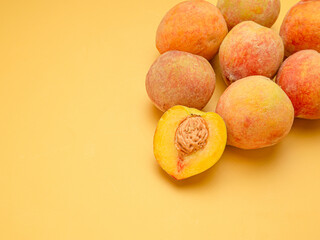 Pile of fresh peaches fruit over a yellow background