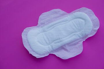 White sanitary pad 
on pink background. Concept: female's hygienic product for period's day. Protect from menstruation blood to stain underwear clothes. Woman healthcare. Intimate hygiene. Top view.