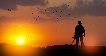 Fototapeta na wymiar Silhouette of soldier standing against the backdrop of a sunset. Greeting card for Veterans Day, Memorial Day, Independence Day. USA celebration. Concept - patriotism, protection, remember honor.