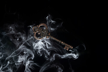 Old key in the smoke, macro shot. Gothick style. Key to knowledge. Concept and idea of...