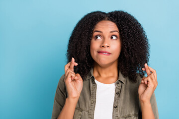 Portrait of pretty person crossed fingers bite lips look empty space isolated on blue color...