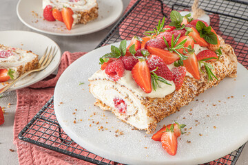 Fototapeta na wymiar Meringue roll with a gentle airy cream, crunchy peanut, mint, rosemary and filling with raspberries and strawberries. Pavlova summer sweet dessert