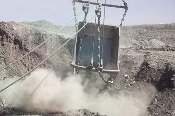 Dragline bucket creating dust whilst working overburden in Queensland coal mine