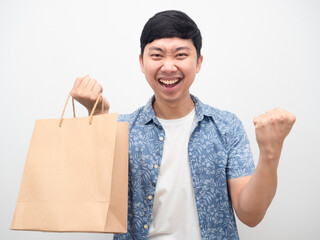 Man satisfyfist up with shopping with paper bag in hand