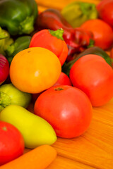 Bright ripe juicy vegetables on a wooden table: tomatoes, onions, carrots, paprika, sweet peppers, copy space, selective focus