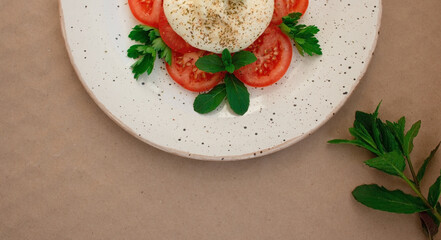 burrata cheese with tomato and herbs on a plate
