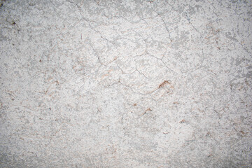 Fotografia frontal de una pared de cemento color gris con huecos y textura vieja y desgastada 