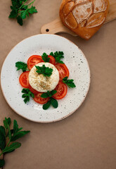 burrata cheese with tomato and herbs on a plate