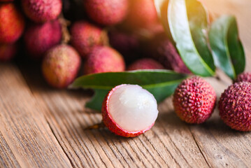 Obraz na płótnie Canvas Lychee fruit and green leaf on wooden background, fresh ripe lychee peeled from lychee tree at tropical fruit Thailand in summer