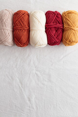 Balls of cotton yarn warm colors on a white table