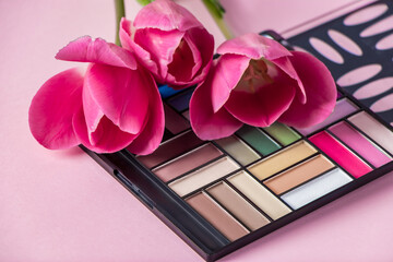 Set of cosmetics and flowers on a pink background. Makeup and beauty products.