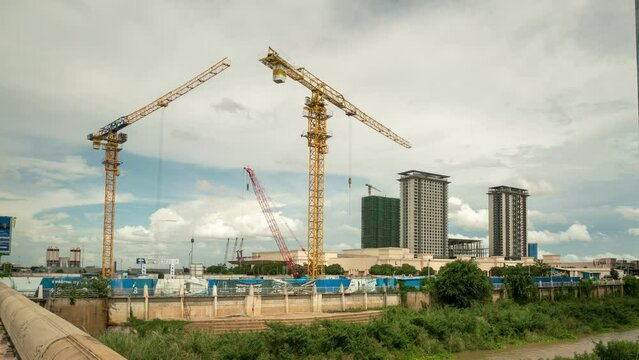 Cranes in construction site, Phnom Pen, a rapidly changing city sky scape with Chinese belt road initiative investment, high rises.  Time lapse of progress in Cambodia.