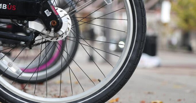 Electric Bike Rental and Terminal in Downtown Urban City. Rent a bike. Bike tire close up.